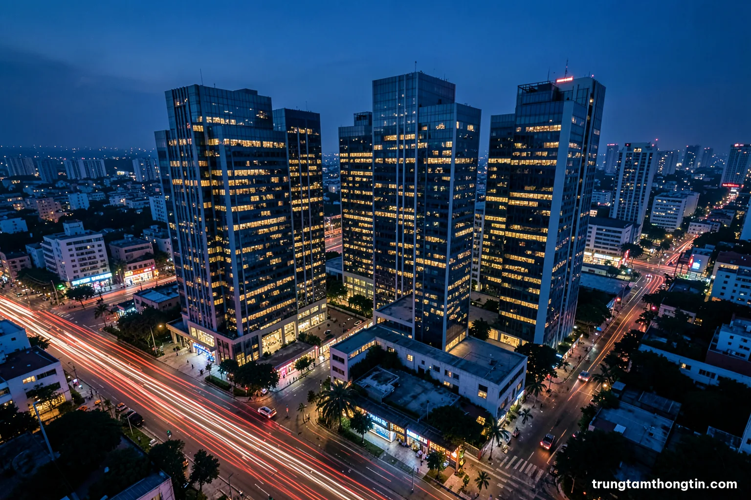 Aerial view at dusk of interlinked office towers in a Vietnamese city, glowing windows forming a web of light, long exposure traffic trails below, indigo and copper palette