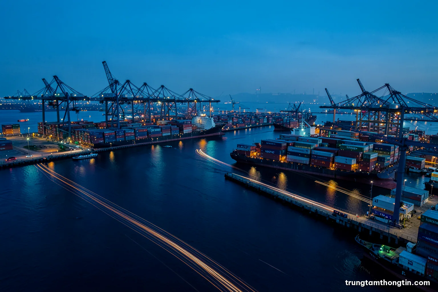 Aerial view of a busy container port at blue hour with ships from many nations, cranes silhouetted, long exposure light trails, teal and orange palette